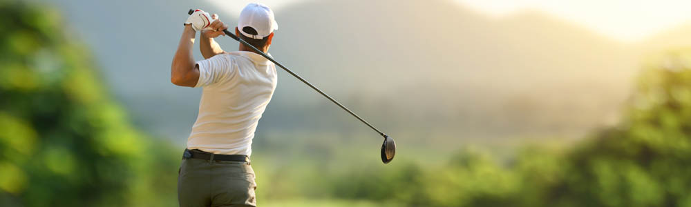 Man swinging the golf club on the golf course